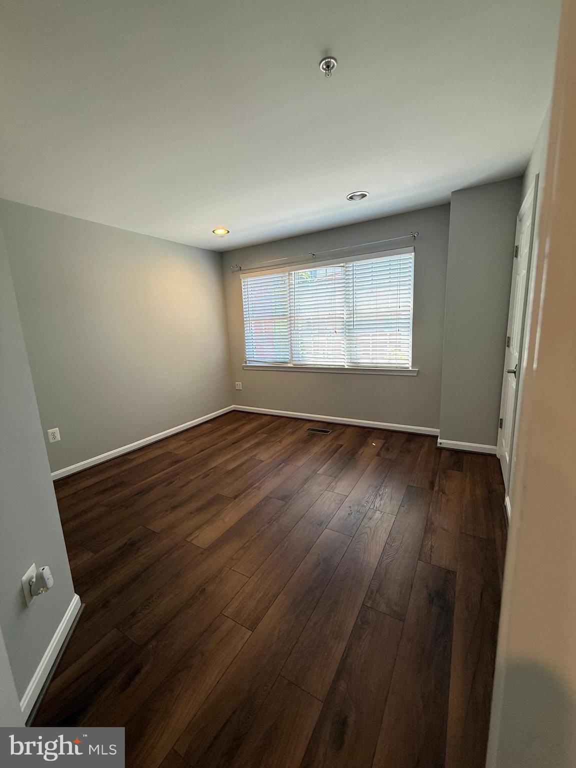 12108 Kinsley Place Reston, VA 20190 - Photo 15 of 17 an empty room with wooden floor and windows