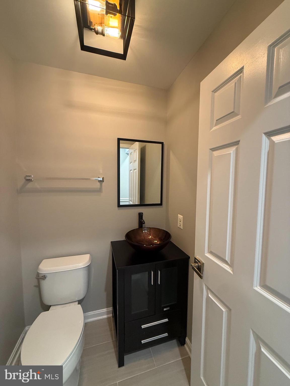 12108 Kinsley Place Reston, VA 20190 - Photo 3 of 17 a bathroom with a toilet a sink and mirror