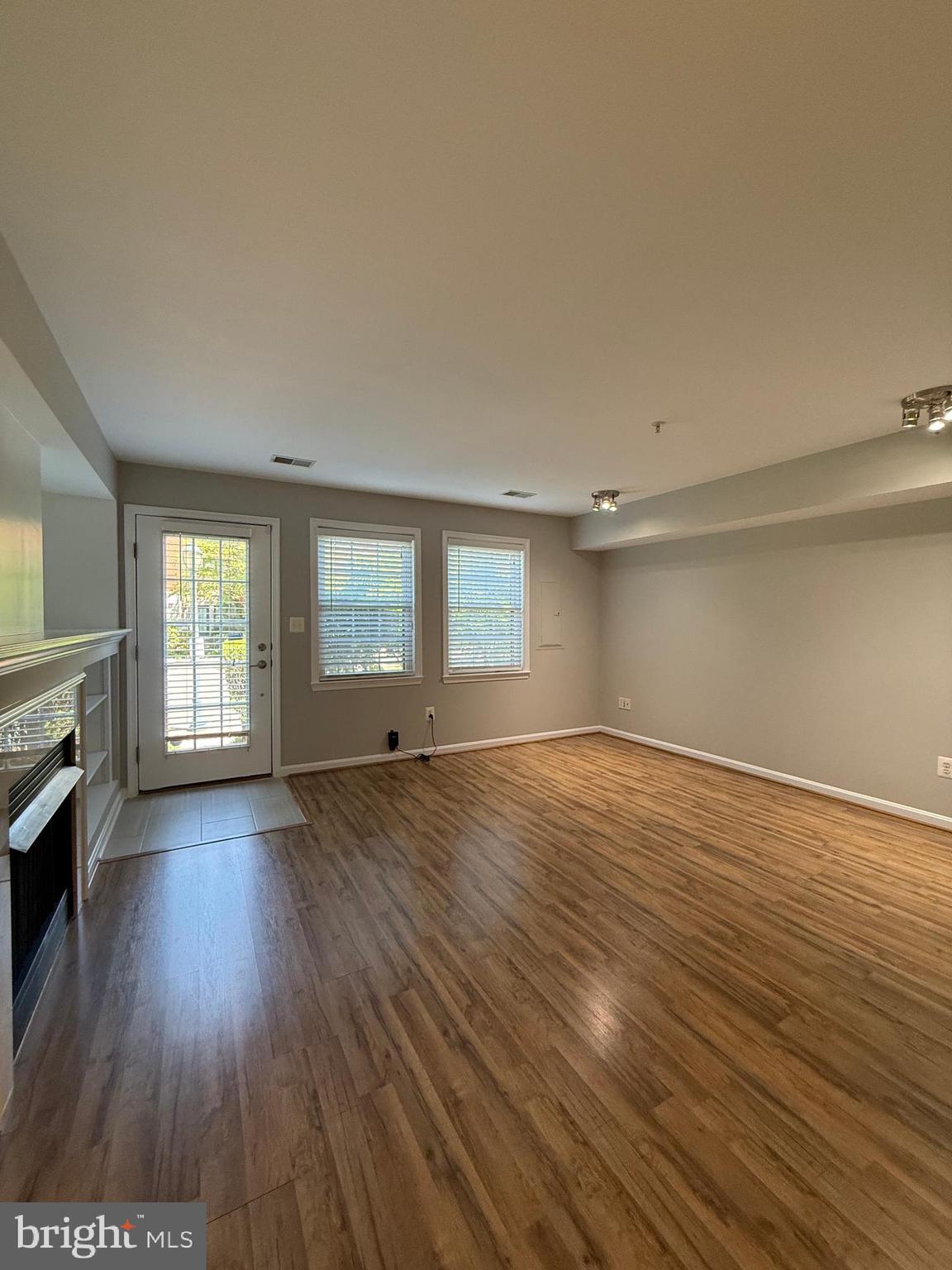 12108 Kinsley Place Reston, VA 20190 - Photo 4 of 17 an empty room with wooden floor and windows