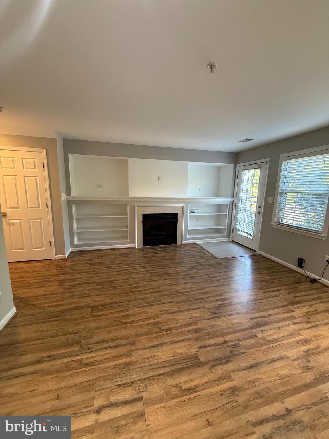 12108 Kinsley Place Reston, VA 20190 - Photo 5 of 17 a view of empty room with wooden floor and fireplace