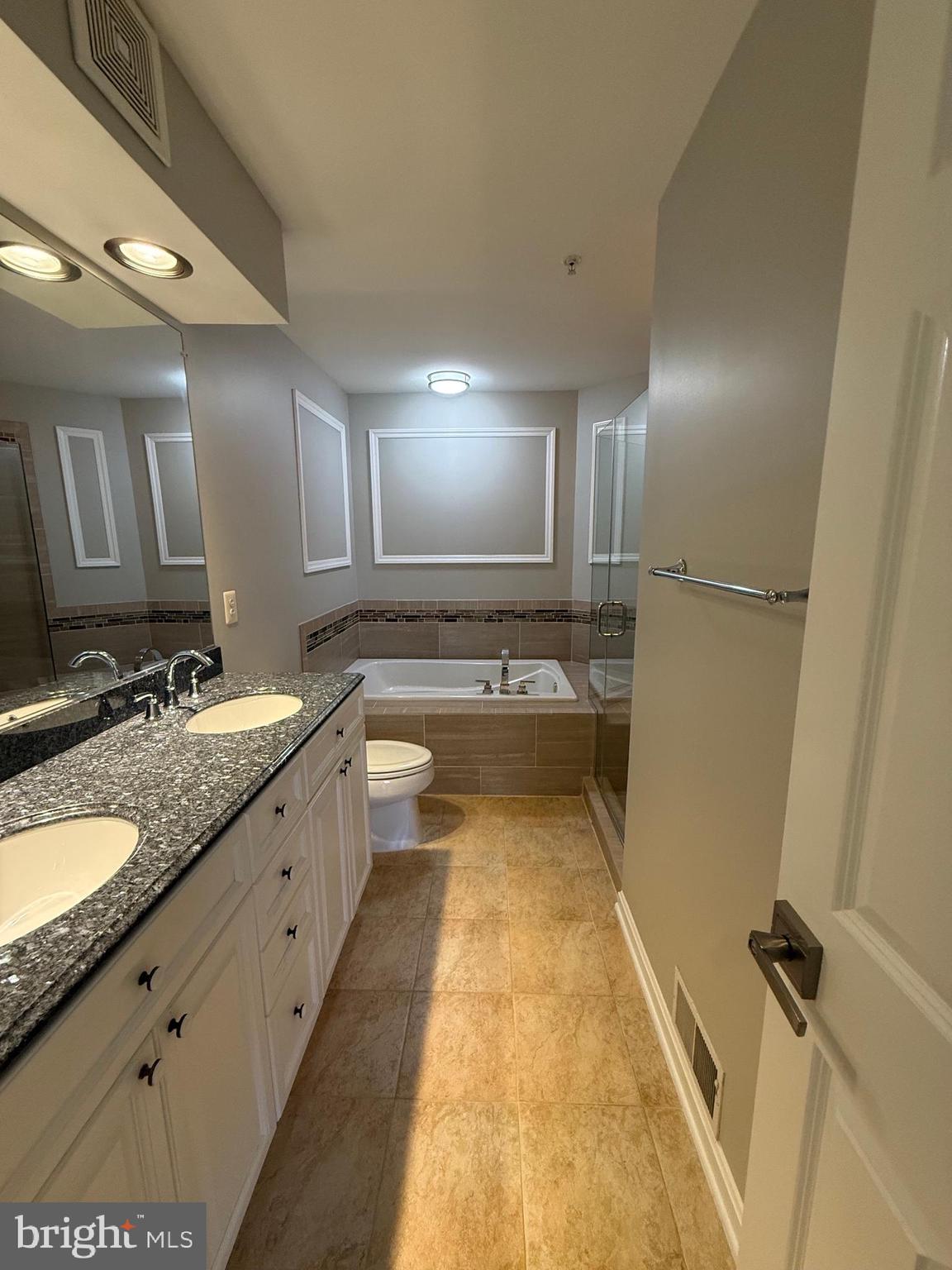 12108 Kinsley Place Reston, VA 20190 - Photo 9 of 17 a spacious bathroom with a granite countertop sink and a bathtub