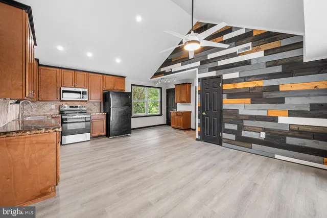 a kitchen with stainless steel appliances granite countertop a refrigerator and a stove top oven