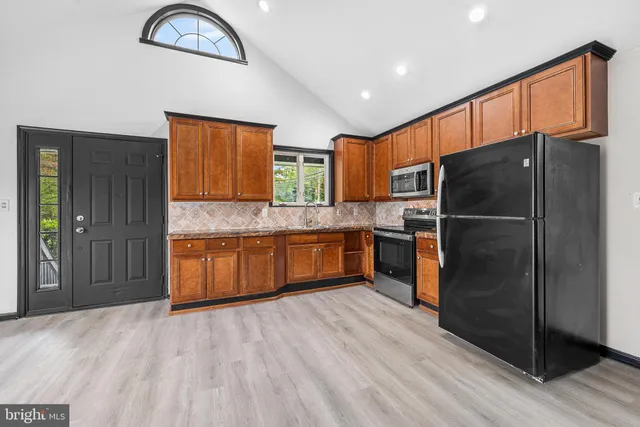 a kitchen with stainless steel appliances granite countertop a refrigerator and a sink