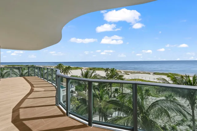 a large white kitchen with a large window and refrigerator