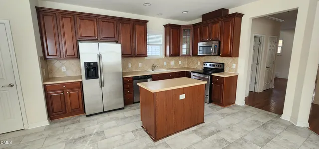a kitchen with stainless steel appliances granite countertop a stove a refrigerator and a sink