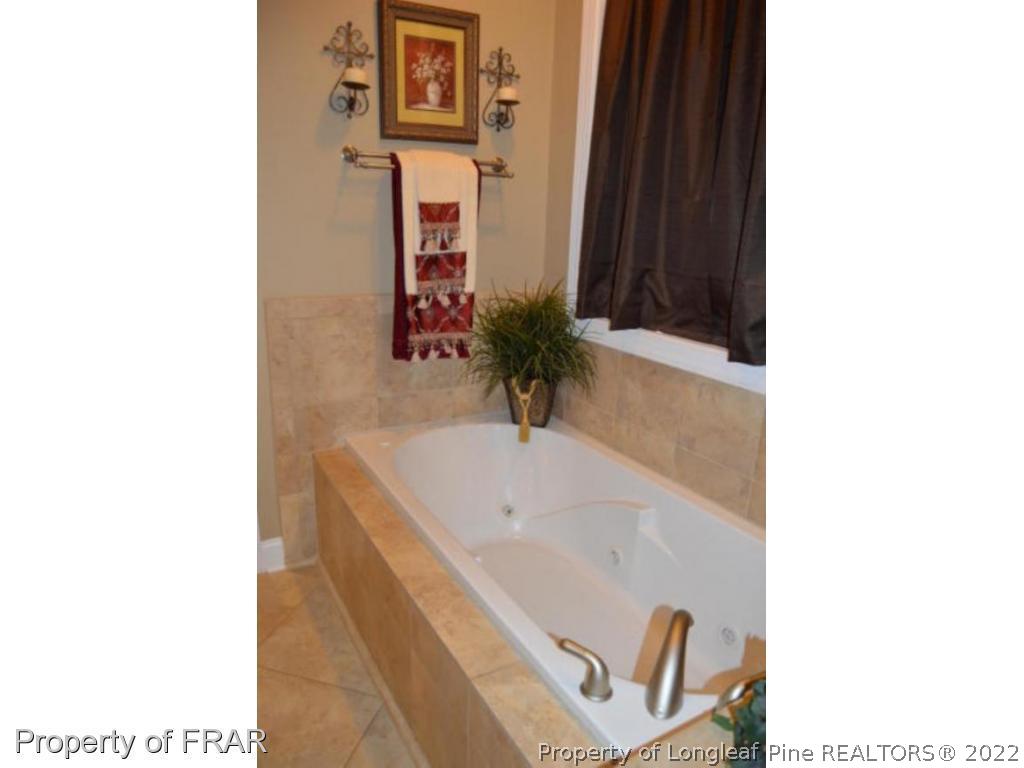 3940 Niagara Carthage Road Whispering Pines, NC 28327 - Photo 12 of 26 a bathroom with a bathtub and a sink