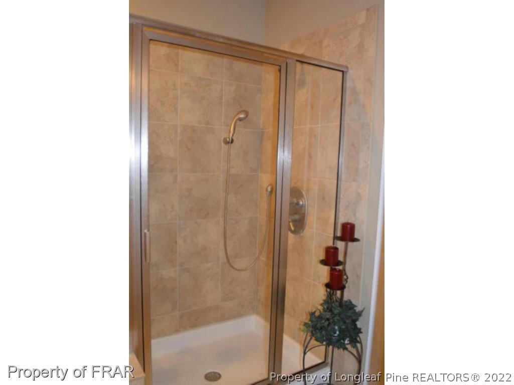 3940 Niagara Carthage Road Whispering Pines, NC 28327 - Photo 13 of 26 a bathroom with a glass shower door