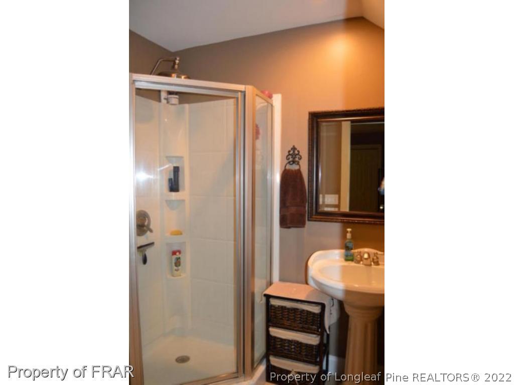 3940 Niagara Carthage Road Whispering Pines, NC 28327 - Photo 18 of 26 a bathroom with a sink a mirror and a shower