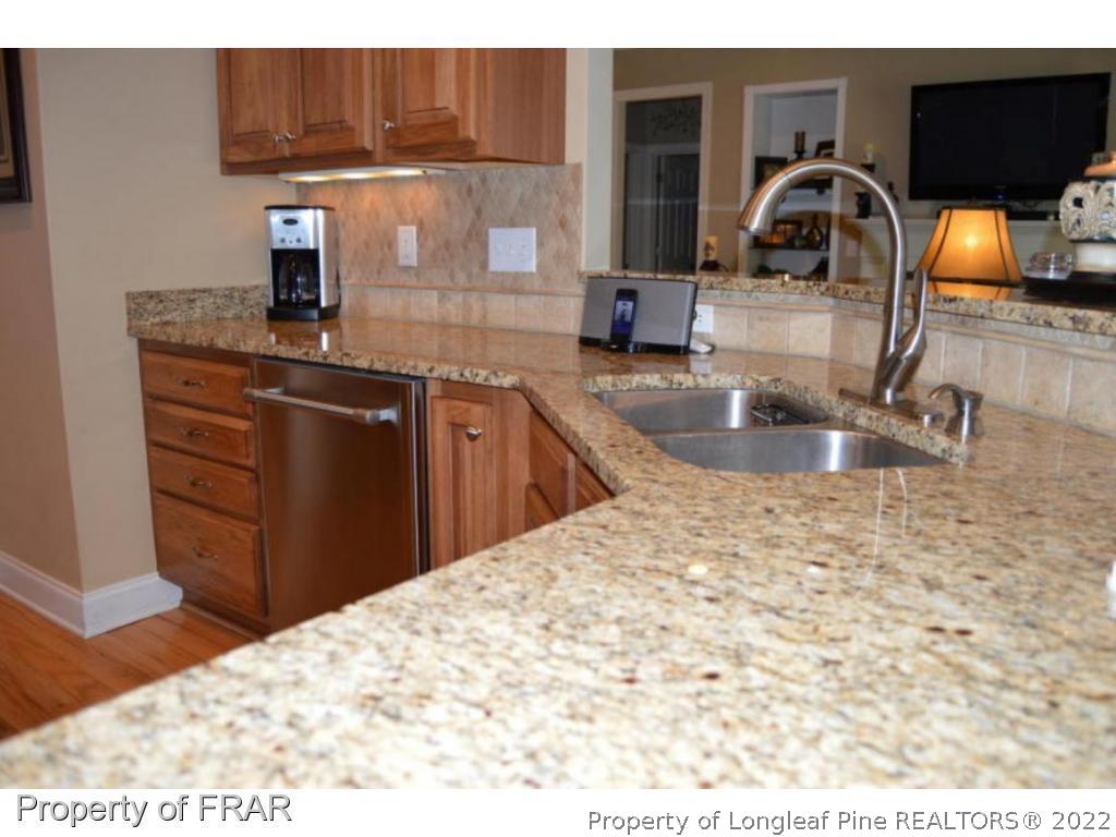 3940 Niagara Carthage Road Whispering Pines, NC 28327 - Photo 5 of 26 a kitchen with kitchen island granite countertop a sink and granite top