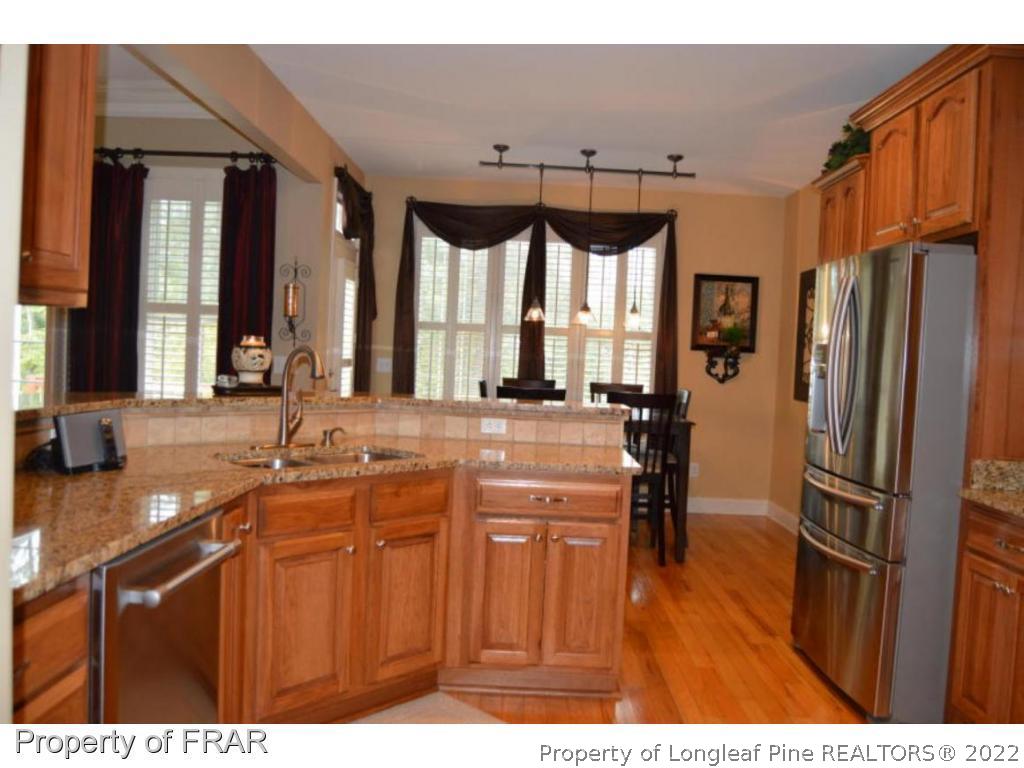 3940 Niagara Carthage Road Whispering Pines, NC 28327 - Photo 6 of 26 a kitchen with stainless steel appliances a sink and a refrigerator