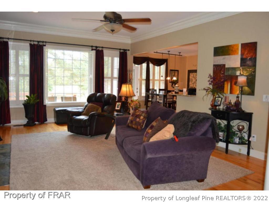 3940 Niagara Carthage Road Whispering Pines, NC 28327 - Photo 7 of 26 a living room with furniture large window and flat screen tv