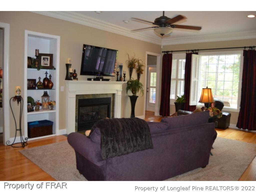 3940 Niagara Carthage Road Whispering Pines, NC 28327 - Photo 8 of 26 a living room with furniture a flat screen tv and a fireplace