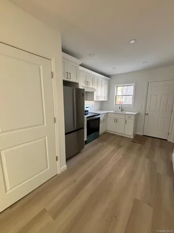 a kitchen with cabinets stainless steel appliances and a window