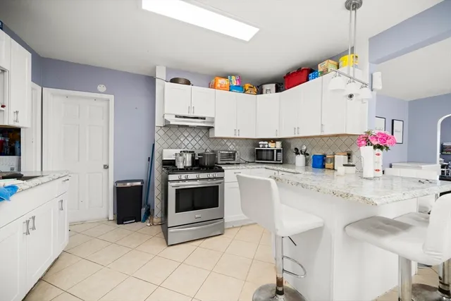 a kitchen with granite countertop a stove a sink and a refrigerator
