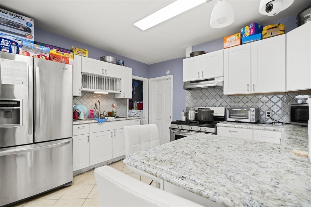 57 Narragansett Street Springfield, MA 01107 - Photo 25 of 41 a kitchen with stainless steel appliances granite countertop a refrigerator sink stove and cabinets