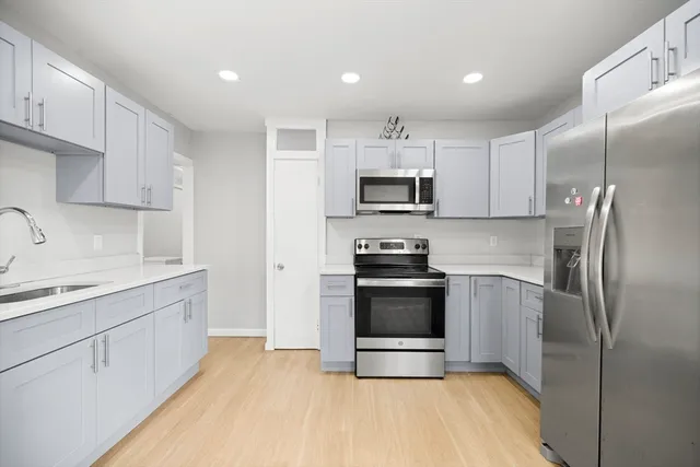 a kitchen with stainless steel appliances a stove a sink and a refrigerator