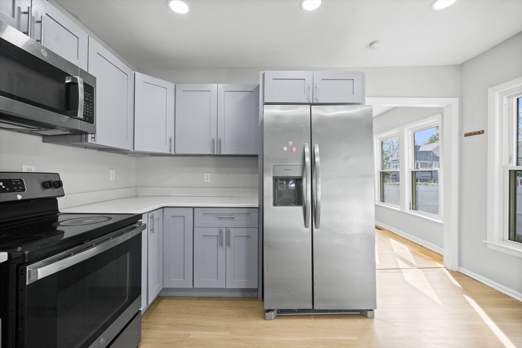 57 Narragansett Street Springfield, MA 01107 - Photo 6 of 41 a kitchen with stainless steel appliances granite countertop a refrigerator and a stove top oven