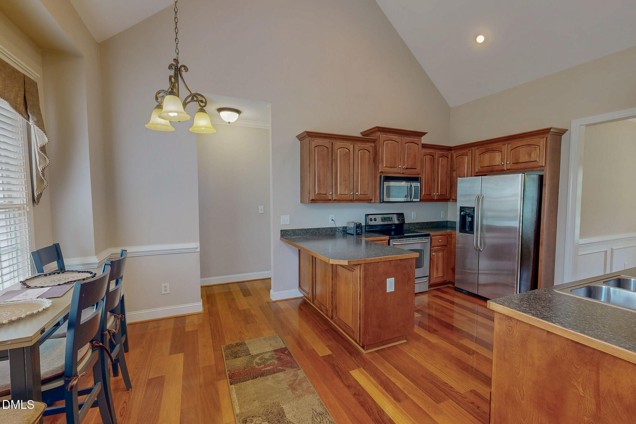 115 Duncan Plantation Road Timberlake, NC 27583 - Photo 28 of 48 a kitchen with stainless steel appliances granite countertop a refrigerator a stove top oven a sink dishwasher a dining table and chairs with wooden floor