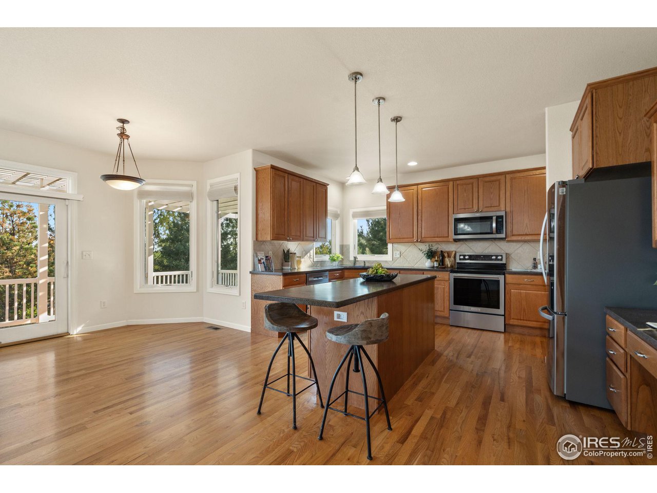 2102 Meander Road Windsor, CO 80550 - Photo 9 of 35 Kitchen with Center Island and Wood Floors