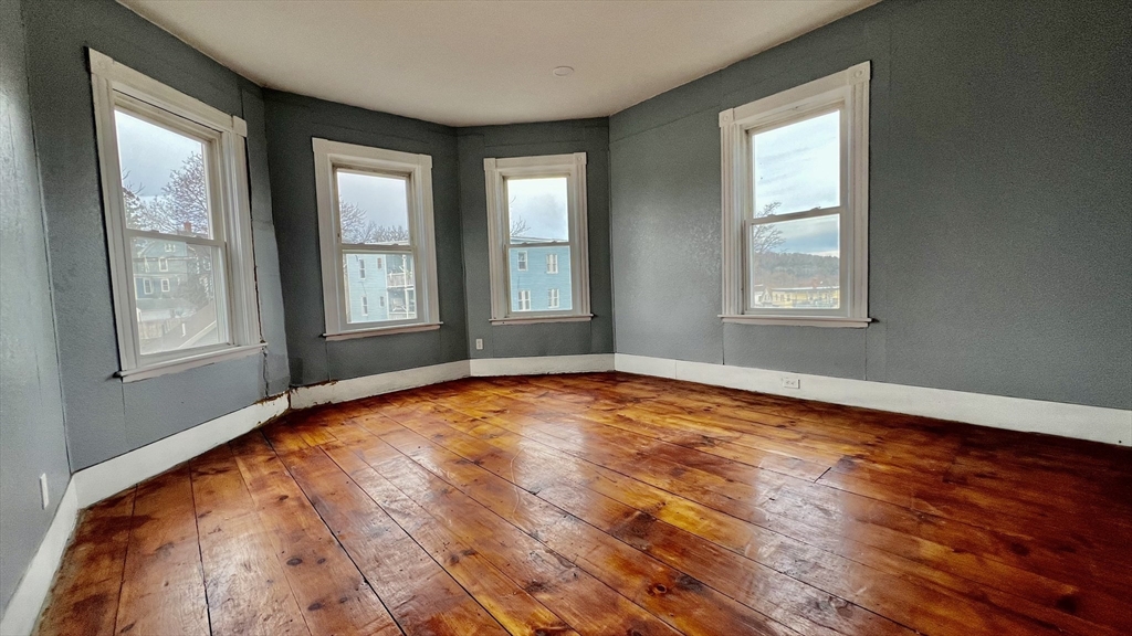 564 Main Street Southbridge, MA 01550 - Photo 3 of 18 an empty room with wooden floor and windows