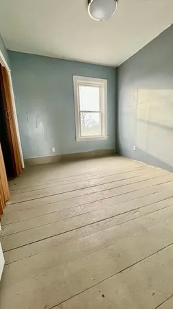 a view of a room with wooden floor and a window