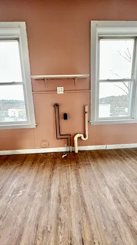a view of a room with wooden floor and a window