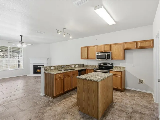 a kitchen with stainless steel appliances granite countertop a stove top oven a sink a counter top space and cabinets