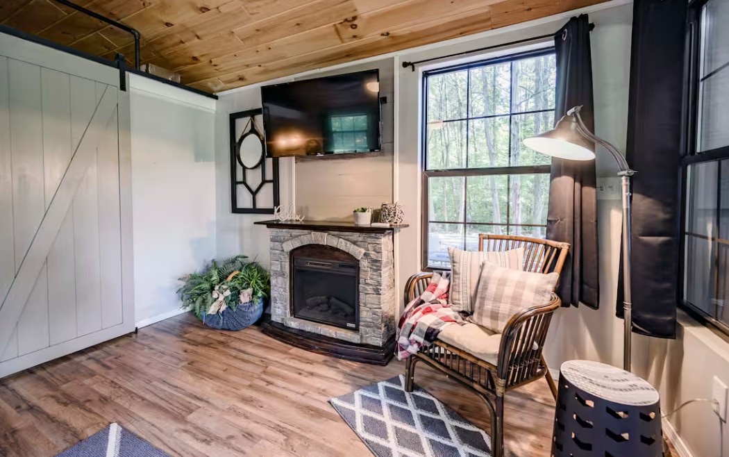 233 Porterfield Road Readyville, TN 37149 - Photo 26 of 32 a living room with furniture a fireplace and a floor to ceiling window