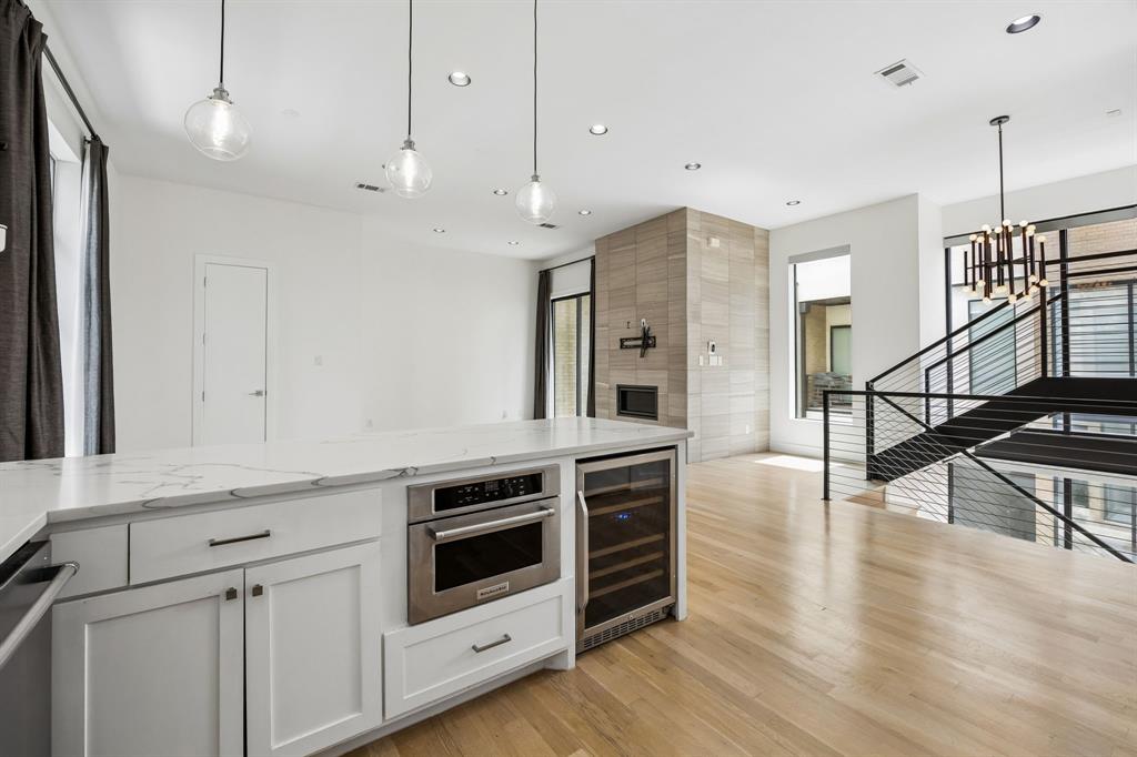 1851 Summit Avenue, Unit 4 Dallas, TX 75206 - Photo 11 of 29 a kitchen with stainless steel appliances granite countertop a stove a refrigerator and a wooden floor