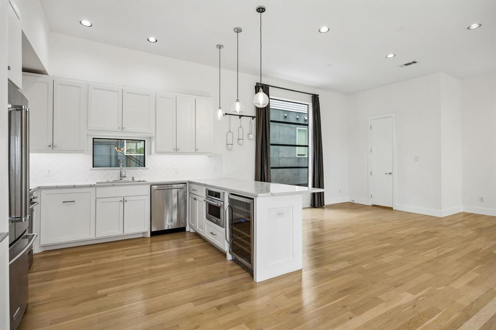 1851 Summit Avenue, Unit 4 Dallas, TX 75206 - Photo 8 of 29 a kitchen with stainless steel appliances granite countertop a stove a sink and white cabinets with wooden floor