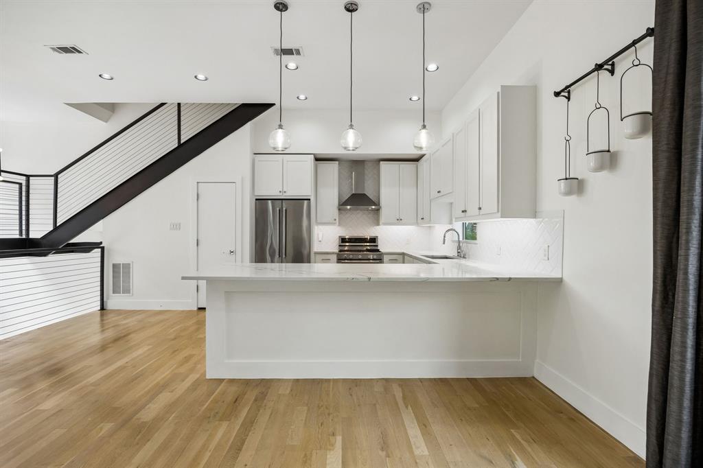 1851 Summit Avenue, Unit 4 Dallas, TX 75206 - Photo 9 of 29 a kitchen with stainless steel appliances a refrigerator a sink dishwasher a oven and white cabinets with wooden floor