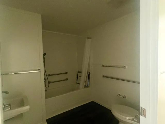 a bathroom with a granite countertop toilet and a shower