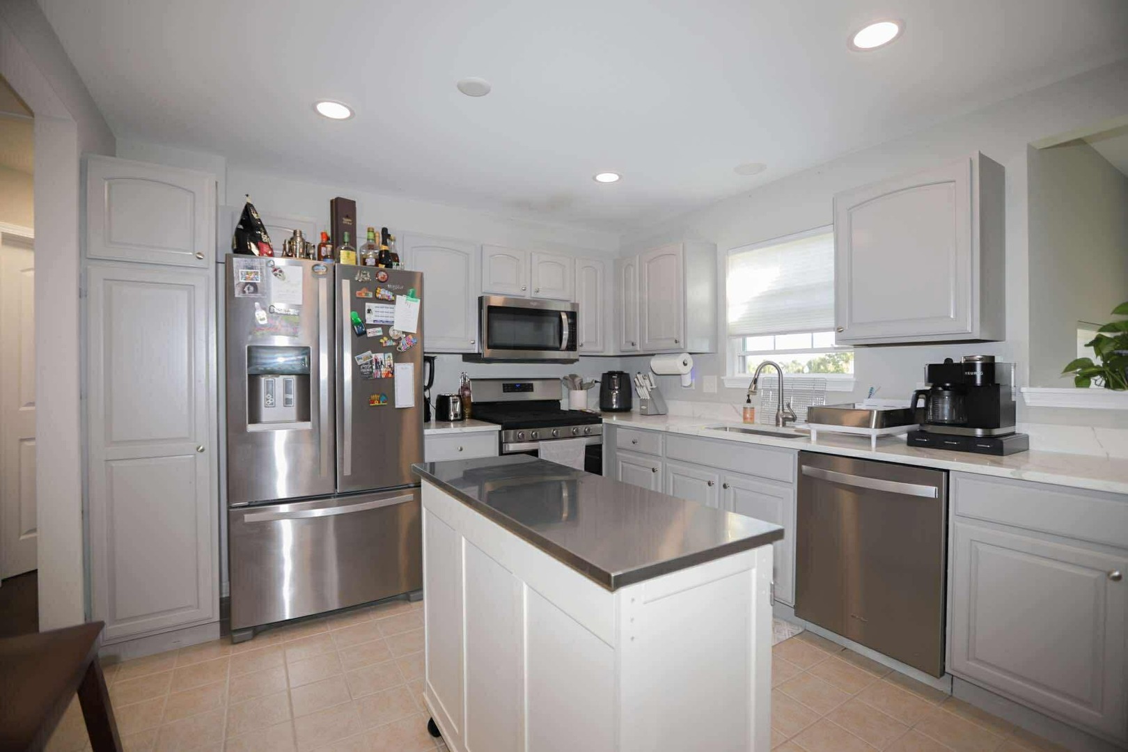 1117 Draper Road, Unit 1117 McHenry, IL 60050 - Photo 2 of 16 a kitchen with a refrigerator a microwave a sink and cabinets
