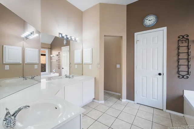 a spacious bathroom with a double vanity sink mirror and shower