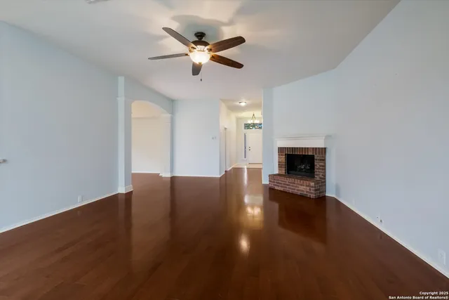 a view of empty room with wooden floor and fireplace