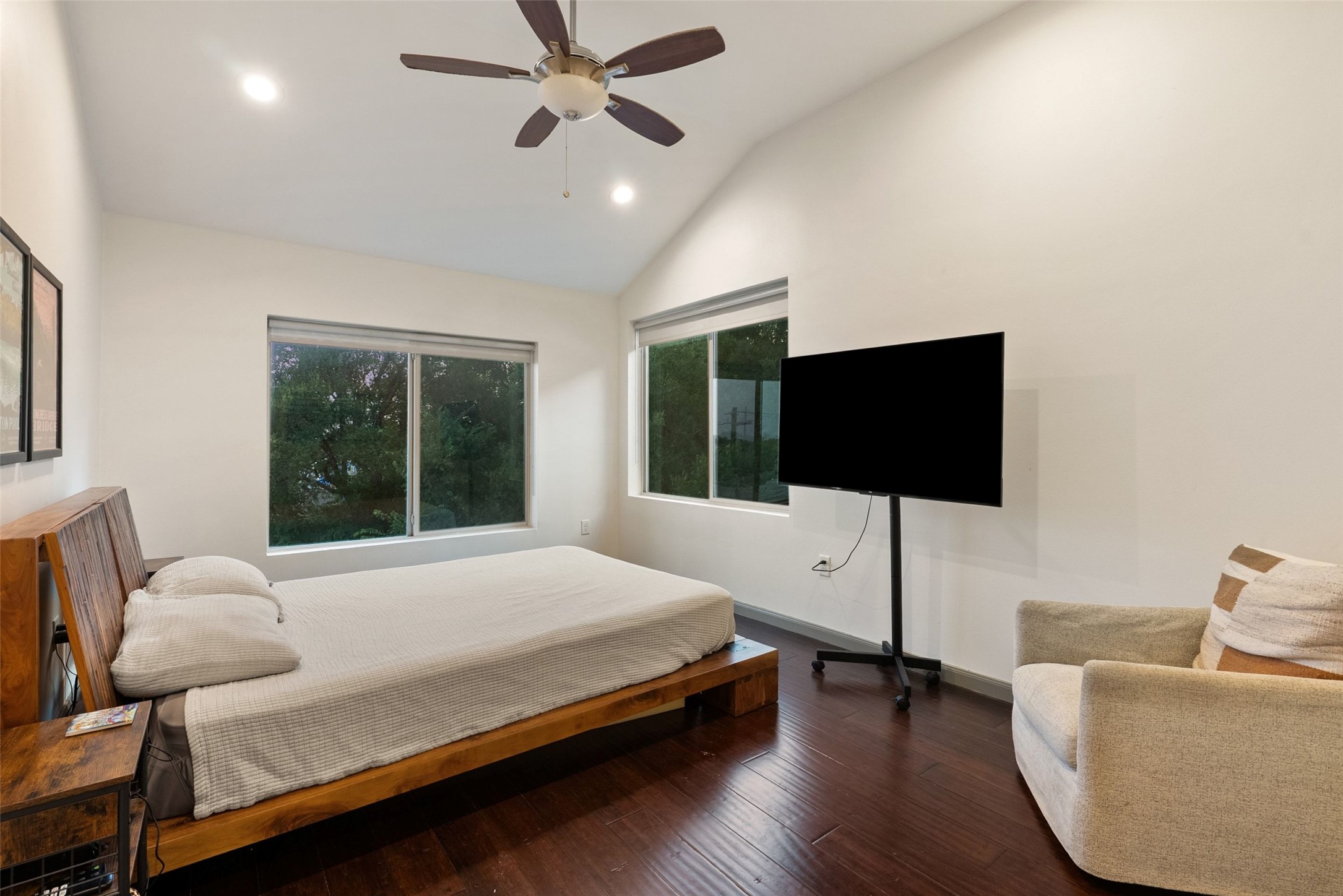 1158 Ridgeway Drive, Unit A Austin, TX 78702 - Photo 11 of 28 A well-lit bedroom with soaring vaulted ceilings and expansive windows offers serene views of the surrounding greenery.