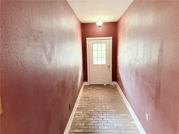 a view of an empty room with wooden floor and windows