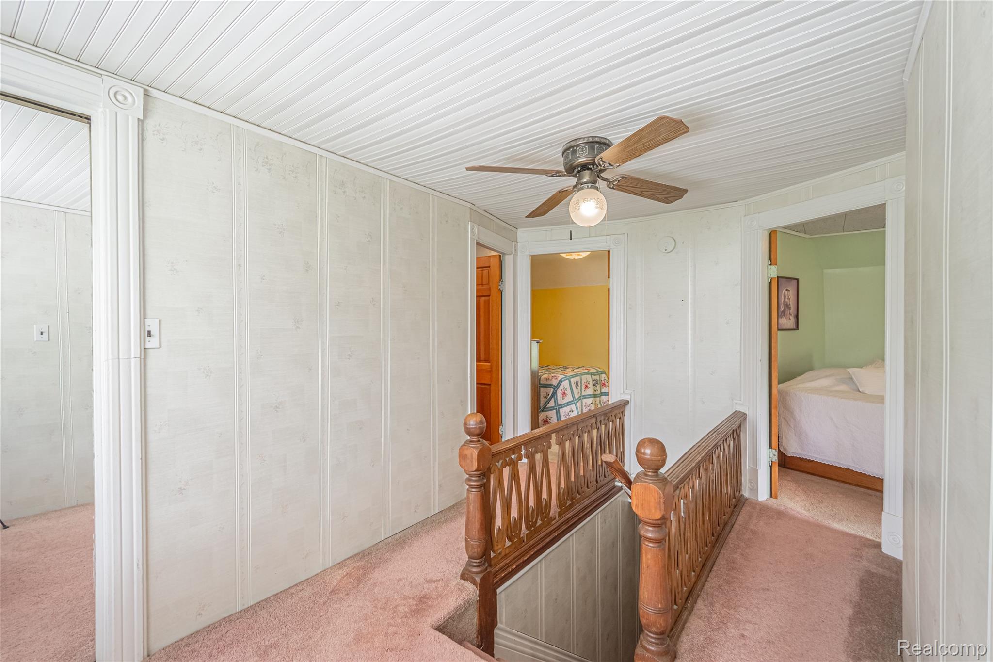 8384 Imlay City Road Avoca, MI 48006 - Photo 34 of 39 Upper landing featuring wood paneling, a ceiling fan with light, and wood spindle railings