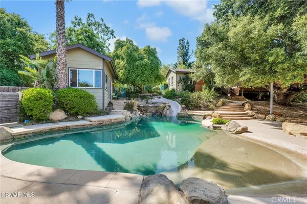 a view of a house with pool and a garden