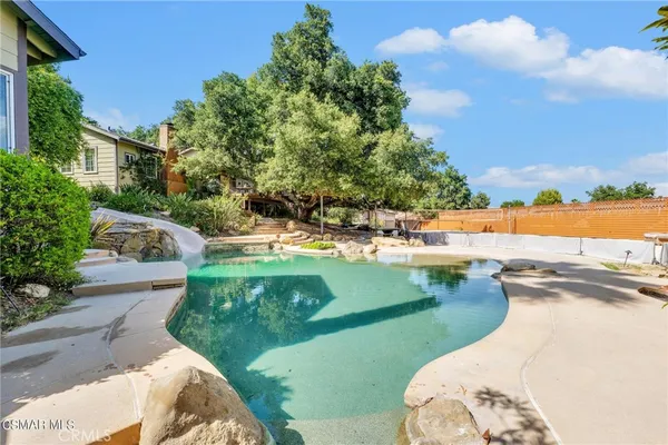 a view of a house with backyard and sitting area