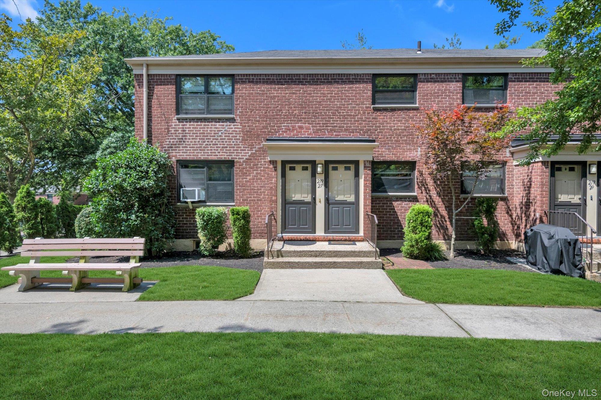 a front view of a house with a yard and potted plants