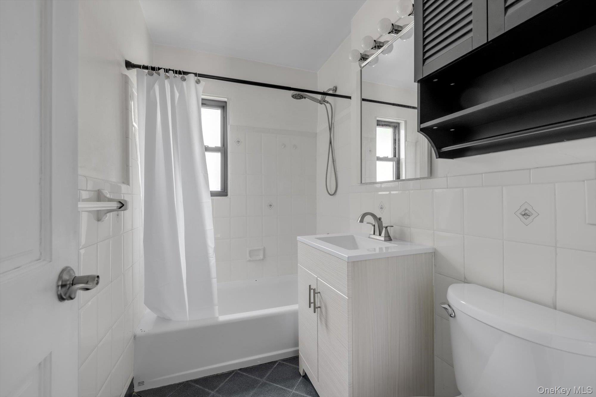 219-27 75th Avenue, Unit 2 Queens, NY 11364 - Photo 9 of 10 a bathroom with a sink a toilet and shower