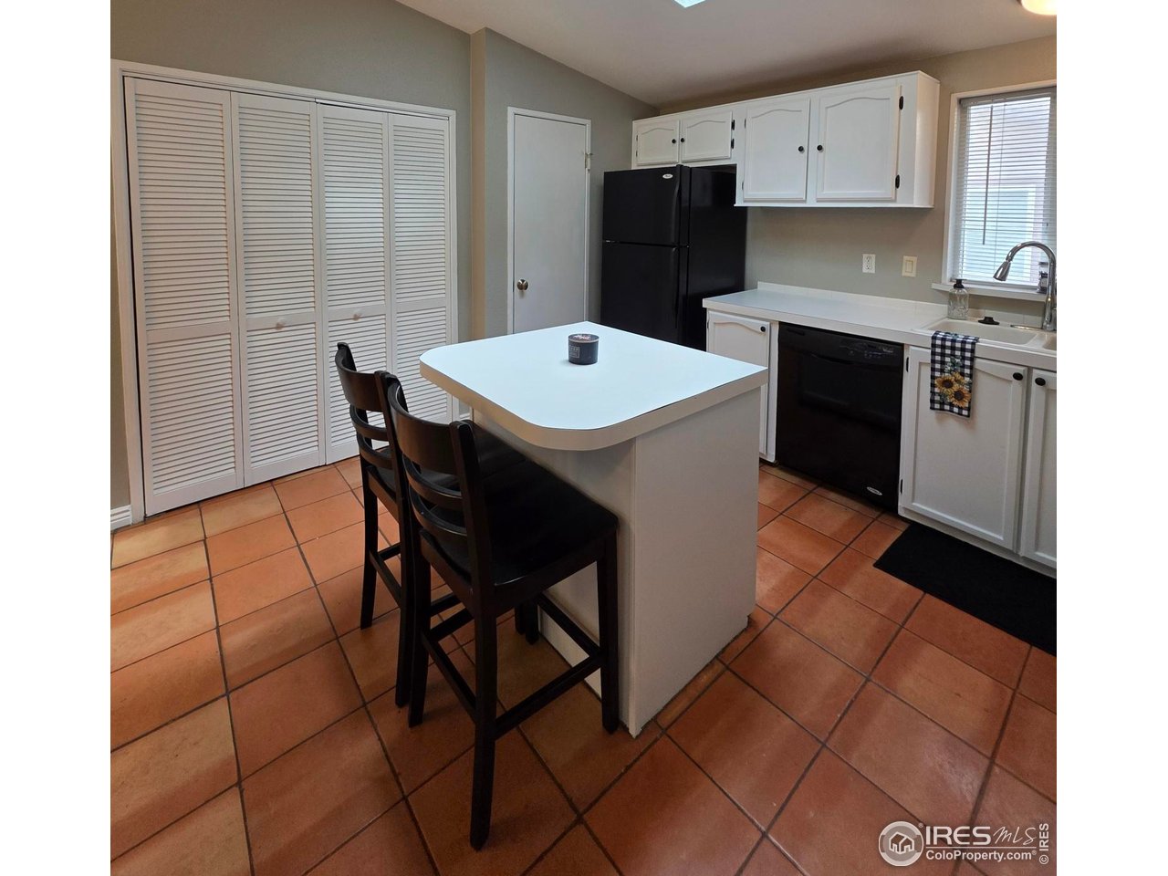 3272 North Rim, Unit 136 Longmont, CO 80504 - Photo 19 of 38 a kitchen with stainless steel appliances kitchen island granite countertop a table chairs sink and cabinets