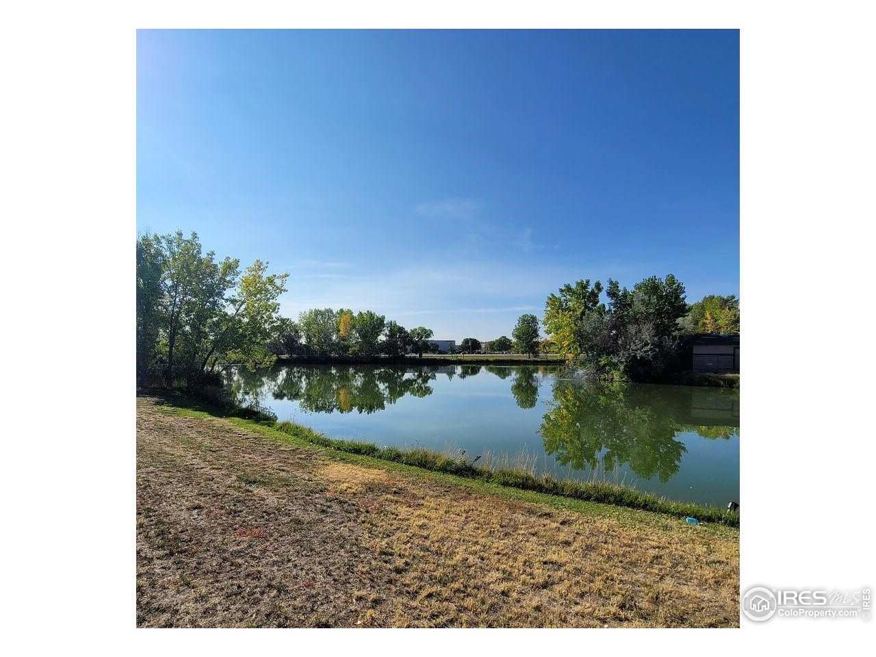 3272 North Rim, Unit 136 Longmont, CO 80504 - Photo 36 of 38 a view of a lake from a yard