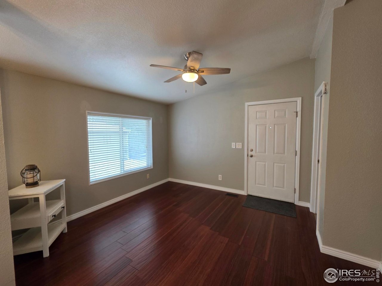 3272 North Rim, Unit 136 Longmont, CO 80504 - Photo 8 of 38 a view of an empty room with a window and wooden floor