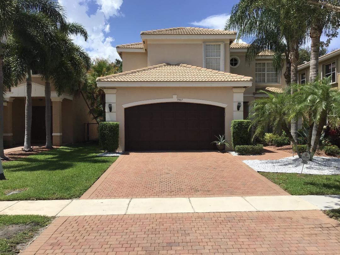 a front view of a house with a garden and trees