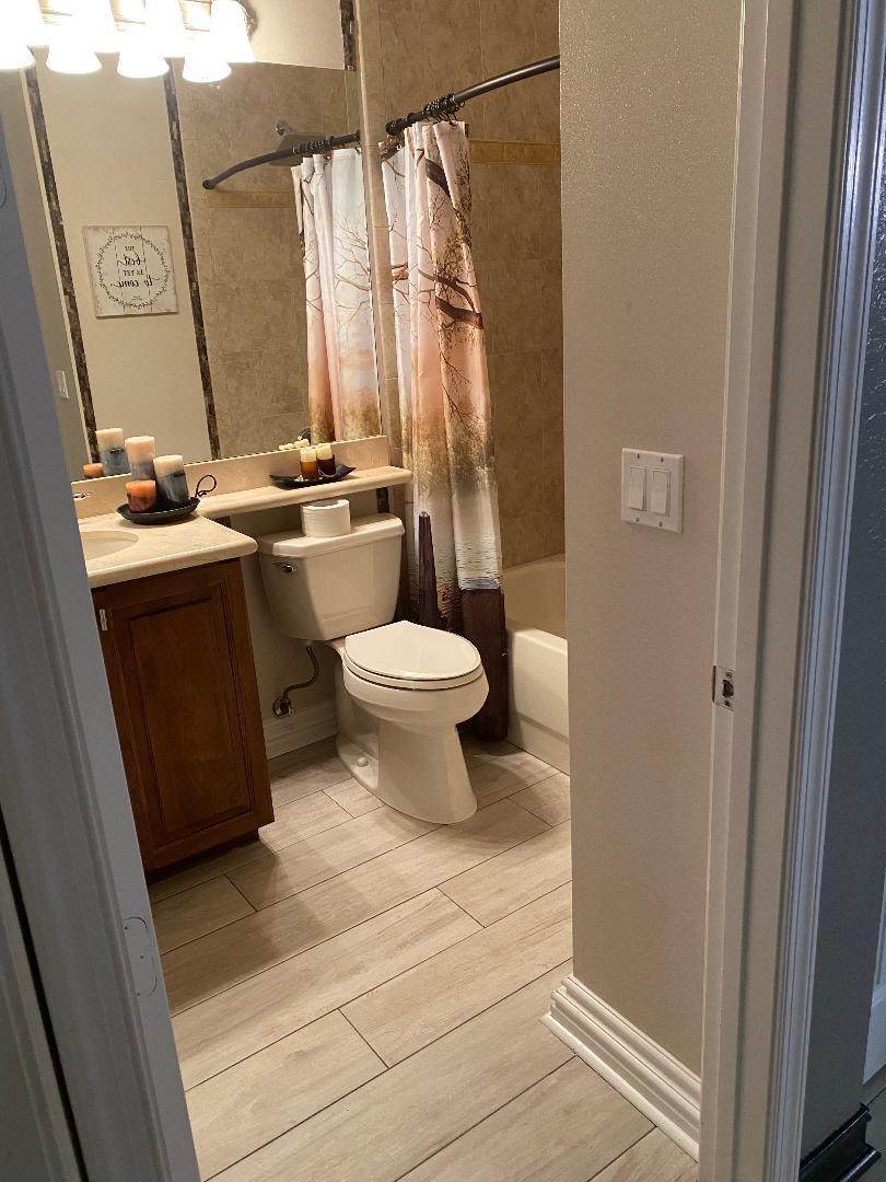 7907 Emerald Winds Circle Boynton Beach, FL 33473 - Photo 12 of 39 a bathroom with a toilet a sink and a mirror