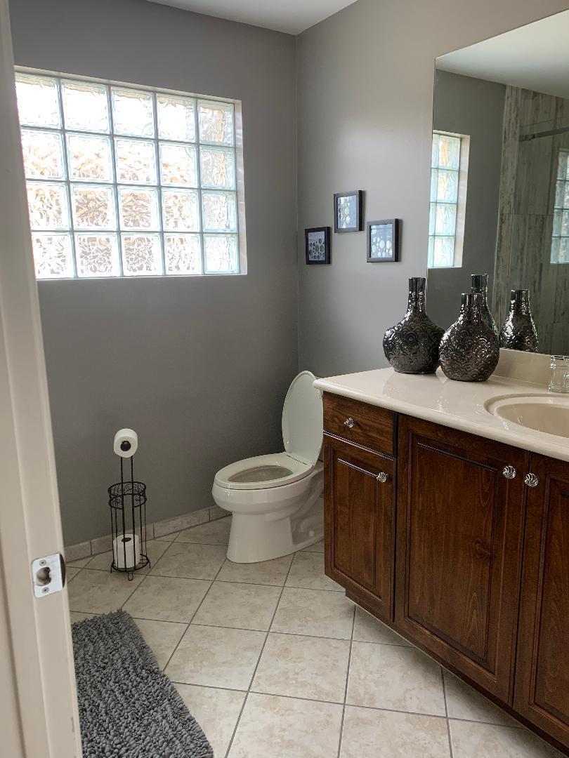 7907 Emerald Winds Circle Boynton Beach, FL 33473 - Photo 35 of 39 a bathroom with a toilet sink and mirror