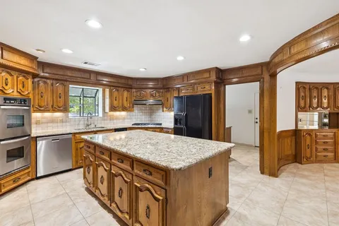 a kitchen with stainless steel appliances granite countertop a stove and a refrigerator