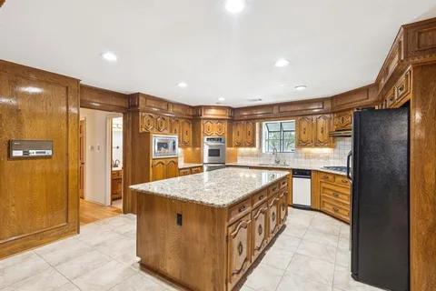 a kitchen with stainless steel appliances granite countertop a refrigerator and a sink